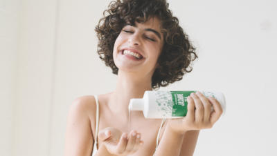 Woman pouring Jasmine tea body wash into hand
